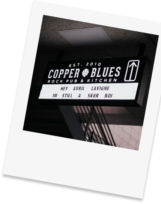 polariod photo of the sign showing tonight's acts at Copper Blues