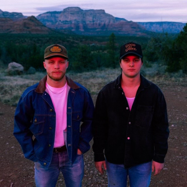 Two men standing against a desert background