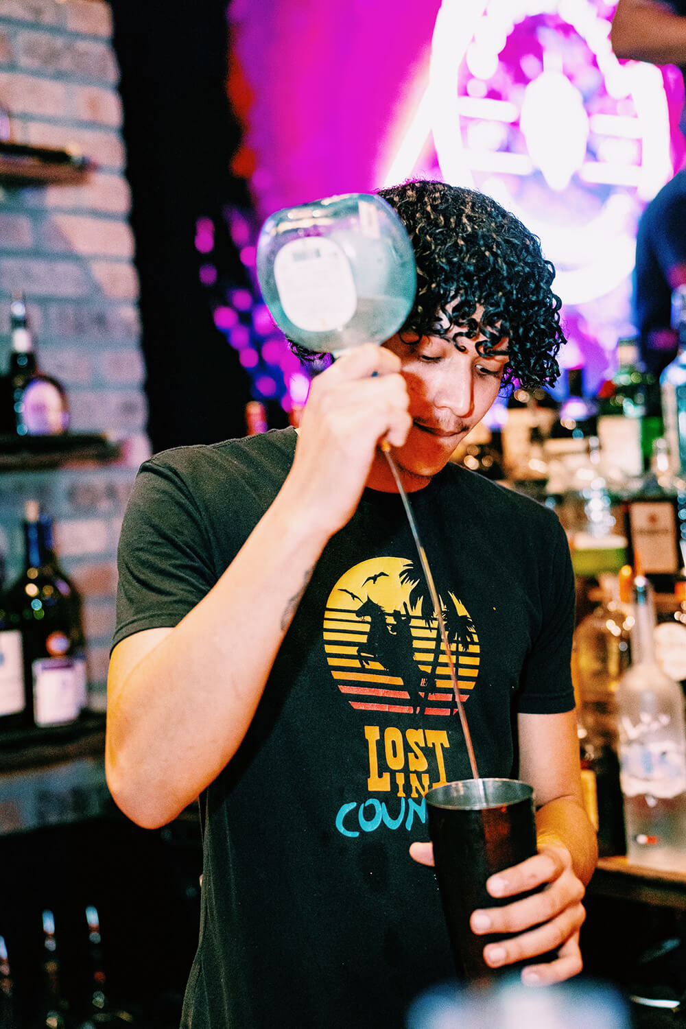 bartender pouring tequila into a shaker